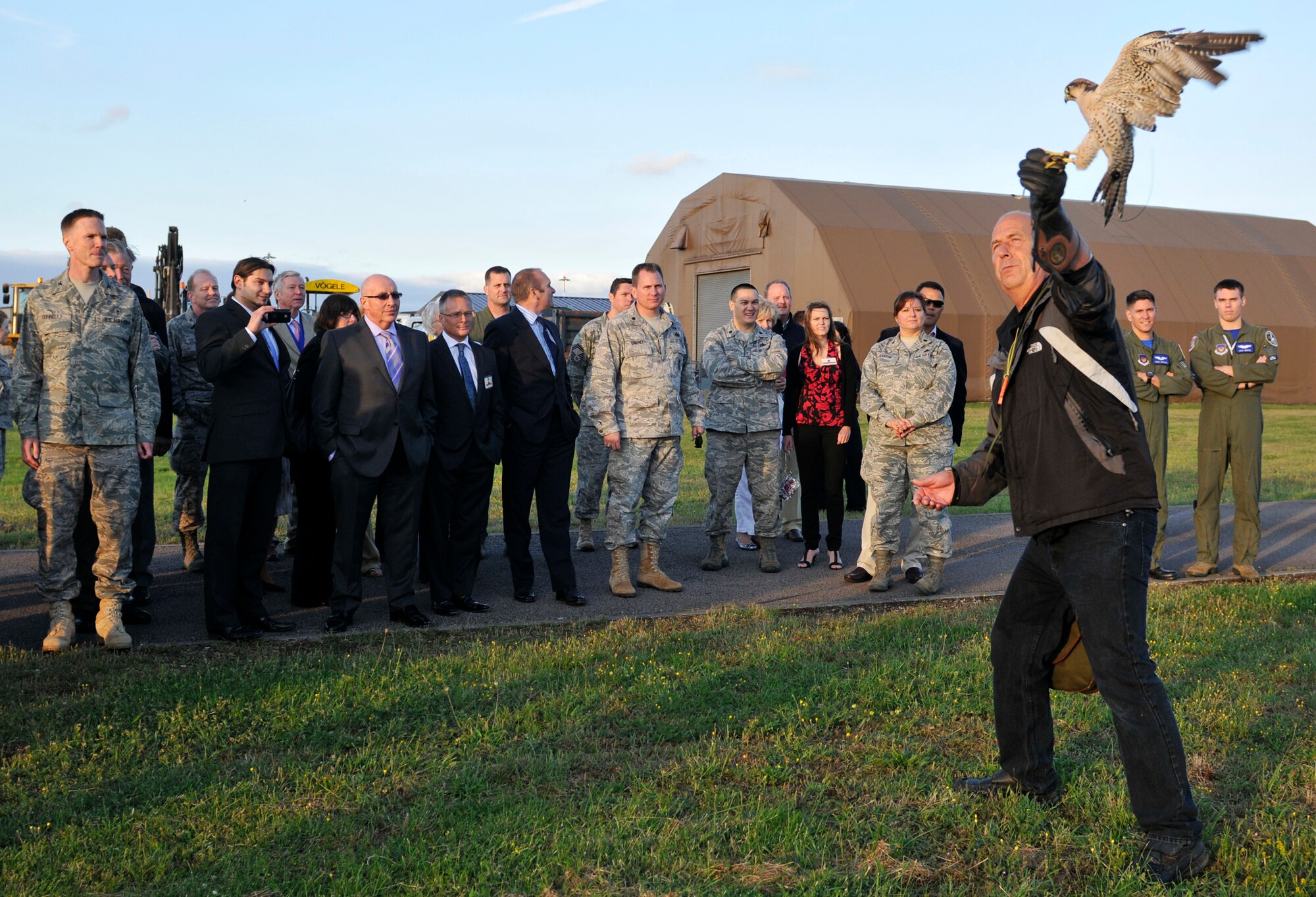 ROYAL AIR FORCE LAKENHEATH, England - Keith Mutton, Phoenix Bird Control falconer (far right), performs a birds of prey demonstration with Mustang, a lanner falcon, during the Honorary Commander's summer reception on RAF Lakenheath, July 29, 2011. The visitors, including seven new honorary commanders, witnessed a birds of prey demonstration, military working dog demonstration, F-15 take-offs and landings, de-contamination exercise and barbecue among other activities. (U.S. Air Force photo/Senior Airman Tiffany M. Deuel)