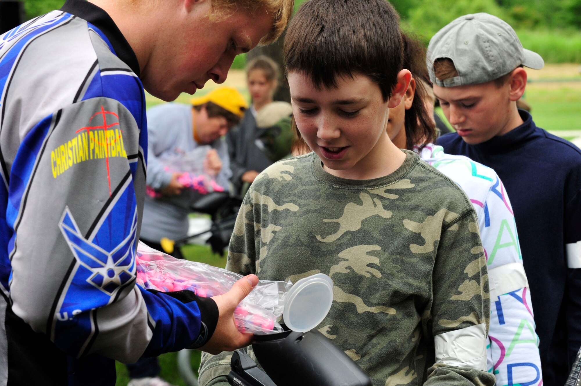 MISAWA AIR BASE, Japan -- Austin Stonecash, left, Youth Paintball Summer Camp instructor, fills Seth Rothstein's, right, son of Col. Michael Rothstein, 35th Fighter Wing commander, hopper with paintballs during the Youth Paintball Summer Camp, Aug. 1. Last year the camp had only 31 children from Misawa participate, this year its estimated more than 100 children will take part. (U.S. Air Force photo/Staff Sgt. Nathan Lipscomb/Released)