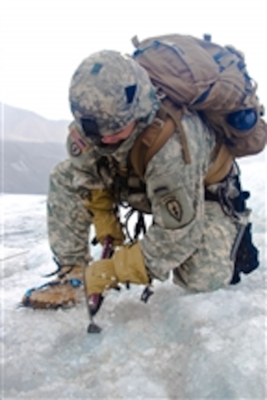 U.S. Army 1st Sgt. Randy Hahn with the 4th Brigade, 25th Infantry Division, clears a spot to set ice screws during a crevasse rescue training exercise at the Black Rapids Training Site in Alaska on July 18, 2011.  Hahn was a student in the basic mountaineering class at the Northern Warfare Training Center at Fort Wainwright.  