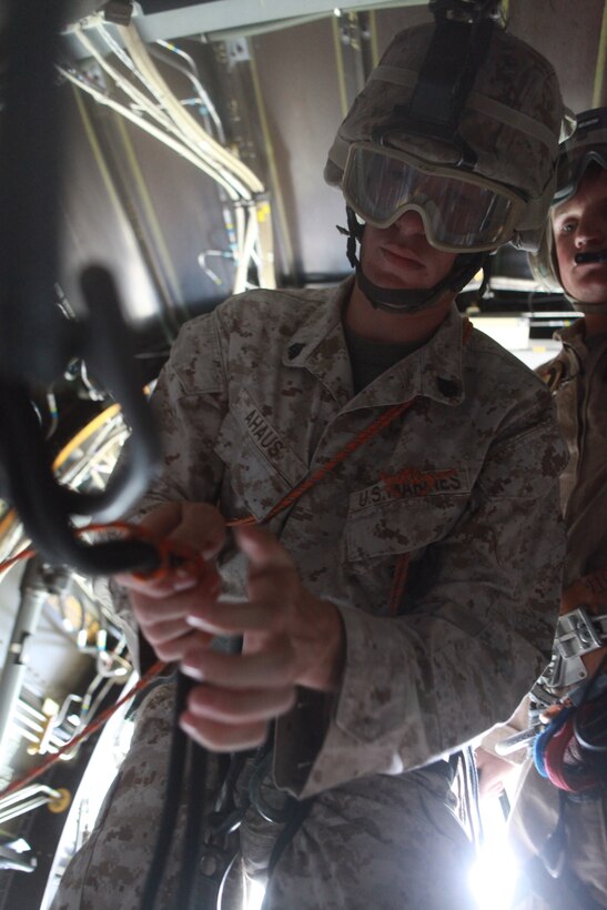 Sgt. Christopher Ahaus, a rifleman with 1st Battalion, 2nd Marine Regiment, 2nd Marine Division, checks a Marine’s knots while acting as a Helicopter Rope Suspension Training Master aboard an MV-22 Osprey at Landing Zone Vulture on Stone Bay, Aug. 2. In the training each Marine performed the role of HRST Master to insure Marines performed operations safely. The majority of students in the course were from units scheduled to attach and deploy with the 24th Marine Expeditionary Unit in September.