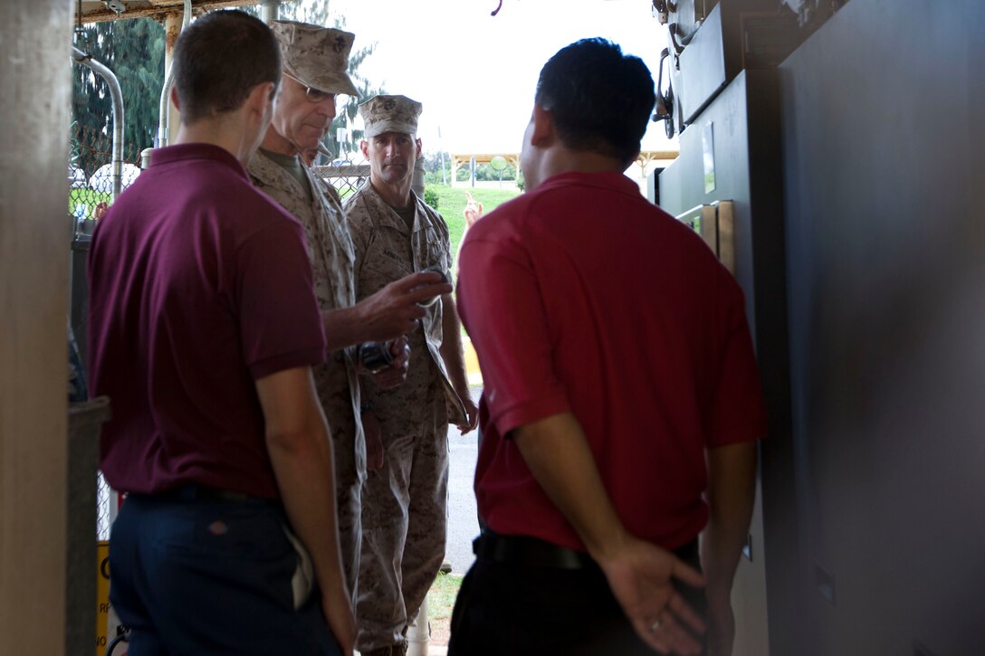 Lt. Gen Duane D. Thiessen, commander of U.S. Marine Corps Forces, Pacific, looks at a sample of remaining waste from the Micro Auto Gasification System here Aug. 3. The MAGS is a system being evaluated here in efforts to improve waste solutions at forward operating bases.