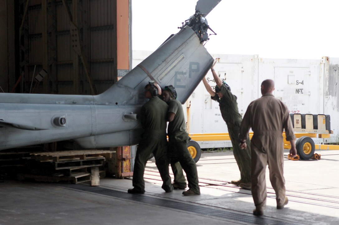 Marines with Marine Medium Helicopter Squadron 265, Marine Aircraft Group 36, 1st Marine Aircraft Wing, III Marine Expeditionary Force, secure aircraft in a hangar in preparation for Typhoon Muifa Aug. 3. The airfield began to shutdown at the onset of Tropical Cyclone Condition of Readiness 2 to ensure the safety of all personnel.