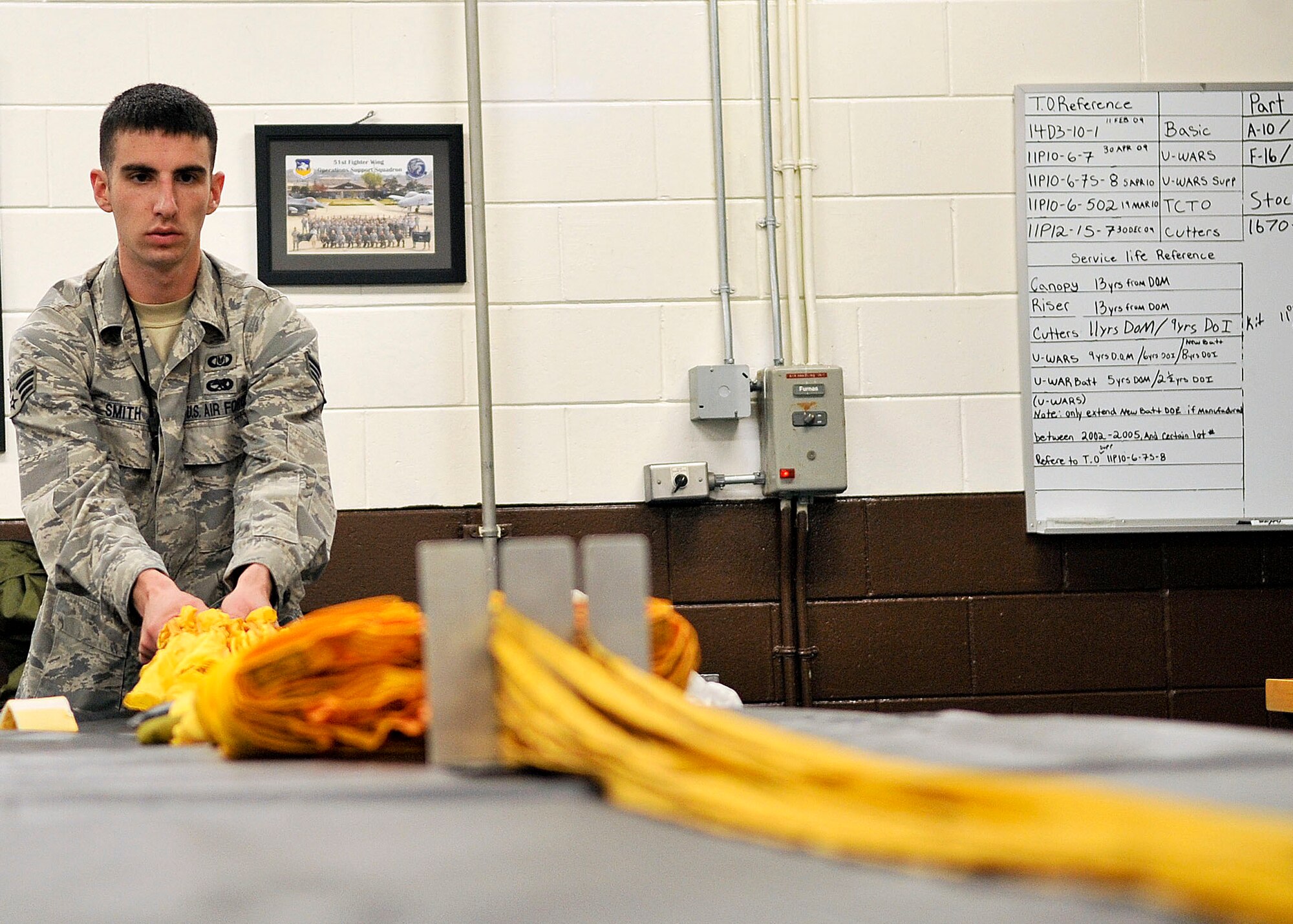 Senior Airman Ryan Smith, 51st Operation Support Squadron air crew flight equipment journeymen, straightens out a de-acceleration canopy before stowing it away. Airman Smith is reassembling the canopy in support of the Republic of Korea’s F-4 fighter plane. (U.S. Air Force Photos by/ Senior Airman Adam Grant)