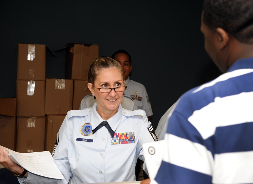 U.S. Air Force Senior Master Sgt. Juliana Graap helps an individual ready reservist with documents at the recruiters' booth at the deployment processing center at Shaw Air Force Base, S.C. Aug. 3, 2011. Graap is a senior recruiter for the 315th Air Wing in Charleston, S.C. During the IRR muster, recruiters spoke to the IRRs about the benefits of re-enlisting. (U.S. Air Force photo/Airman 1st Class Tabatha L. Duarte)(Released)