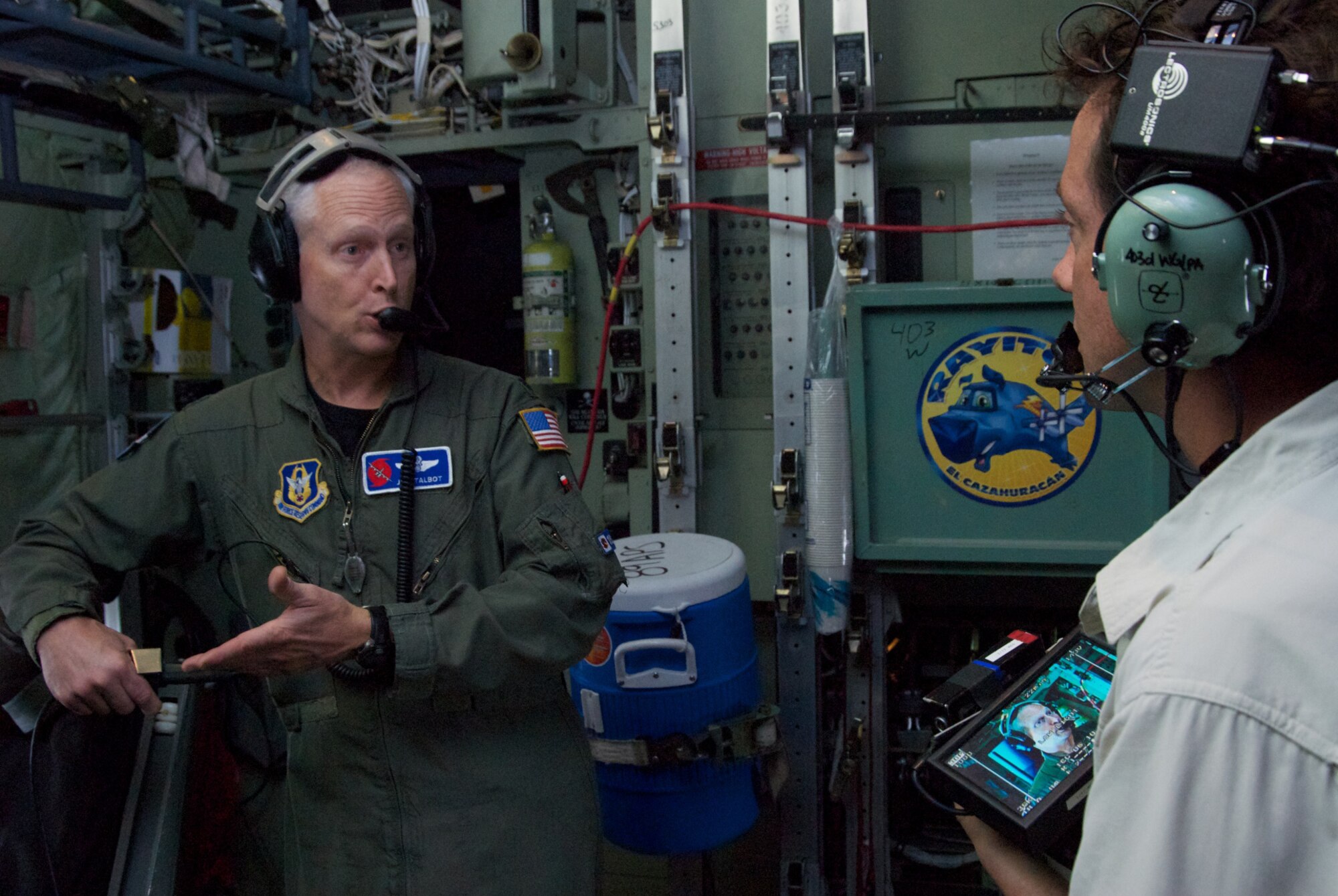Lt. Col. Jon Talbot, 53rd Weather Reconnaissance Squadron Aerial Reconnaissance Weather Officer, explains the job of an ARWO to Christian D'Andrea, High Noon Productions, during a flight into Tropical Storm Don June 29. Talbot also explained how the Hurricane Hunters collect weather data from storms in order to provide the National Hurricane Center with information that will help improve forecasts. (U.S. Air Force photo by Capt. J. Justin Pearce)