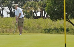 Senior Airman Brad Nicholson putts his golf ball, Aug. 2, 2011, during a Professional Golfers Association of America military appreciation event. The event was held to announced that active duty military will be able to attend the 2012 PGA Championship free of charge. Nicholson is from the 628th Contracting Squadron. (U.S. Air Force photo/Airman 1st Class Jared Trimarchi)