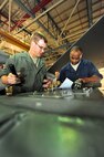 MINOT AIR FORCE BASE, N.D. -- Staff Sgt. Jordan Ellis, 5th Aircraft Maintenance Squadron aircraft armament systems technician and Tech Sgt. Iickyra Jones, 5th AMXS aircraft armament systems team chief, look over the armor systems checklist during a routine inspection of a B-52H Stratofortress, here Aug. 3. Aircraft armament systems technicians plan, organize and direct maintenance activities by performing armament systems maintenance functions tests before connecting electrically actuated explosives and propellants to effectively achieve mission success. (U.S. Air Force Photo/Senior Airman Jesse Lopez) 