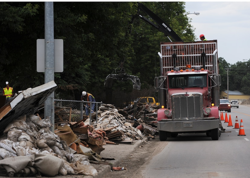 MINOT, N.D. -- City workers begin picking up damaged goods along the flood-damaged streets of downtown Minot here Aug. 3. Due to the severe 2011 Minot flood, many residents have been forced out of their homes. (U.S. Air Force photo/Senior Airman Ashley N. Avecilla)
