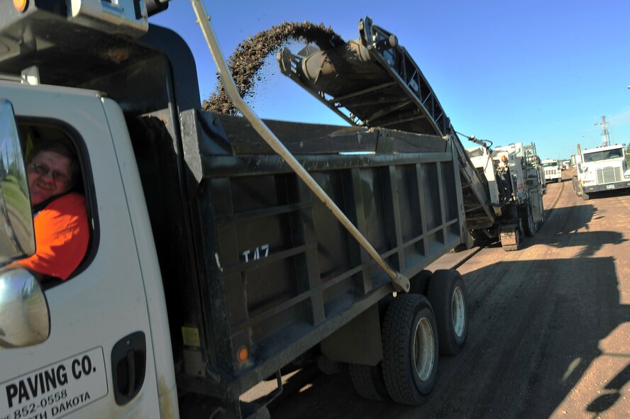 MINOT AIR FORCE BASE – Contractors repair pot holes and reconstruct the road along Missile Avenue to the front gate, resulting in detours through base housing, here Aug. 02. This project will improve the roads on base as well as add a turning lane to relieve the traffic surrounding the shoppette. (U.S. Air Force Photo/ Senior Airman Jesse Lopez)