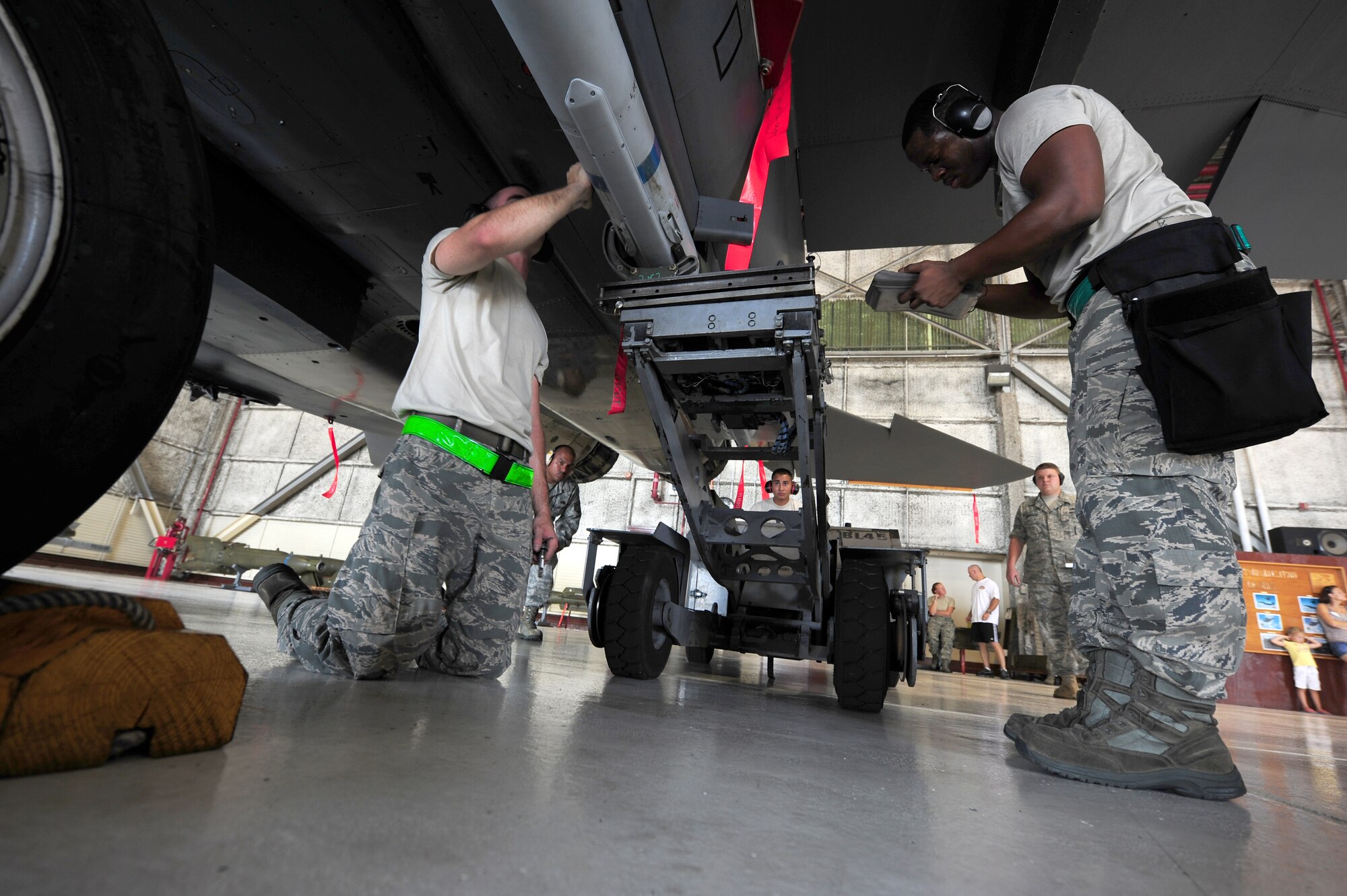 SEYMOUR JOHNSON AIR FORCE BASE, N.C. – Staff Sgt. Ryon Morgan (right) checks a technical order while Senior Airmen Andrew Hillis and Michael Lowery position an AIM-120 on a conformal fuel tank munitions rack during a quarterly load crew competition here July 29, 2011. Airmen are required to follow technical orders when working with an aircraft to ensure nothing is overlooked. The 335th Aircraft Maintenance Unit crew walked away with second place. Morgan, 335th AMU weapons load crew one-man, is a native of Fairfax, Va., Hillis, 335th AMU weapons load crew two-man, hails from Crossville, Tenn., and Lowery, 335th AMU weapons load crew three-man, is from Maxton. (U.S. Air Force photo by Senior Airman Rae Perry/RELEASED)