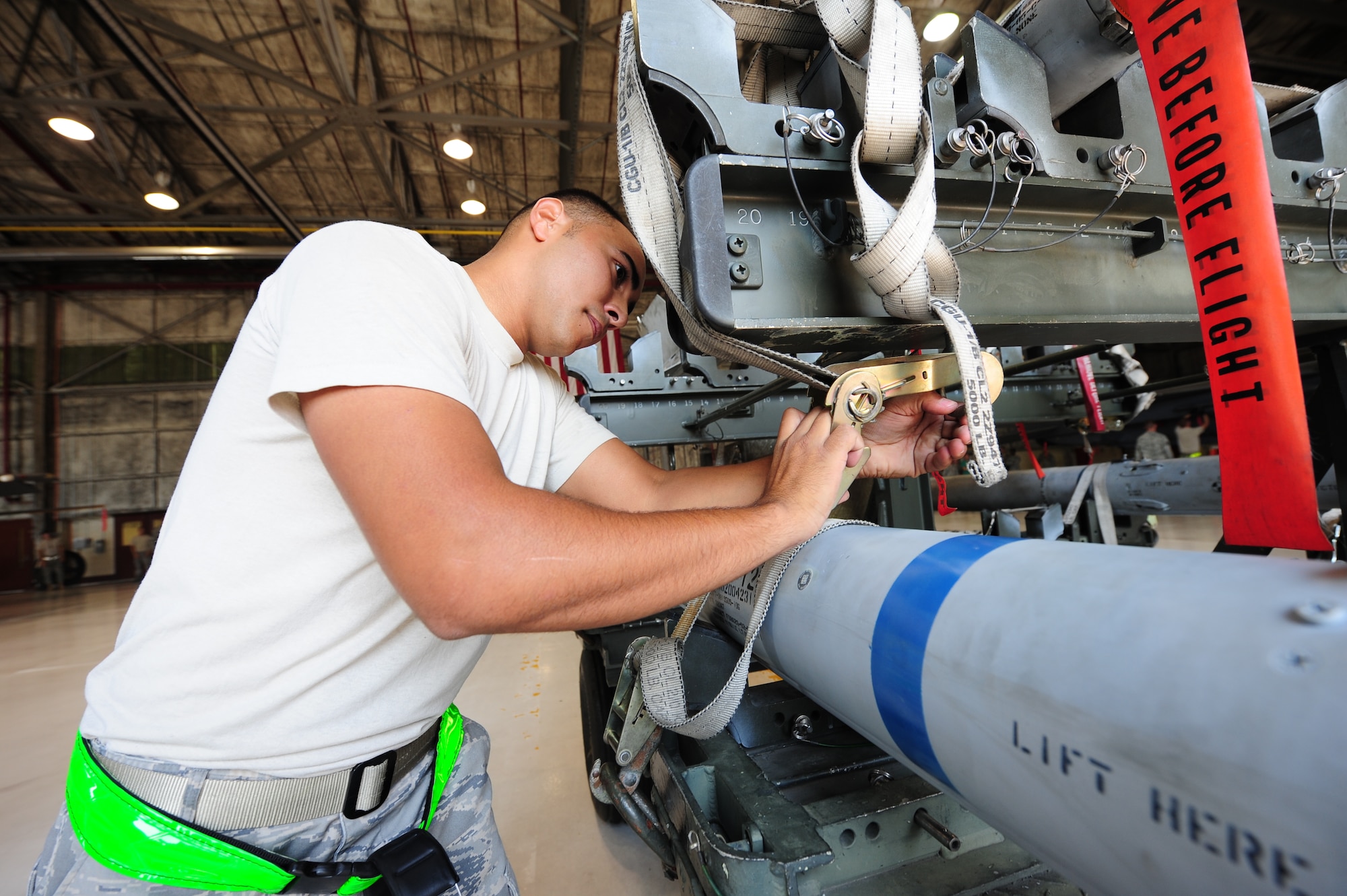 SEYMOUR JOHNSON AIR FORCE BASE, N.C. – Senior Airman Andrew Hillis loosens the straps securing an AIM-120 to a transportation cart during a weapons load crew competition here July 29, 2011. Airmen had 30 minutes to load three different types of munitions to specific locations on an F-15E Strike Eagle. Hillis, 335th Aircraft Maintenance Unit weapons load crew two-man, is a native of Crossville, Tenn. (U.S. Air Force photo by Senior Airman Rae Perry/RELEASED)