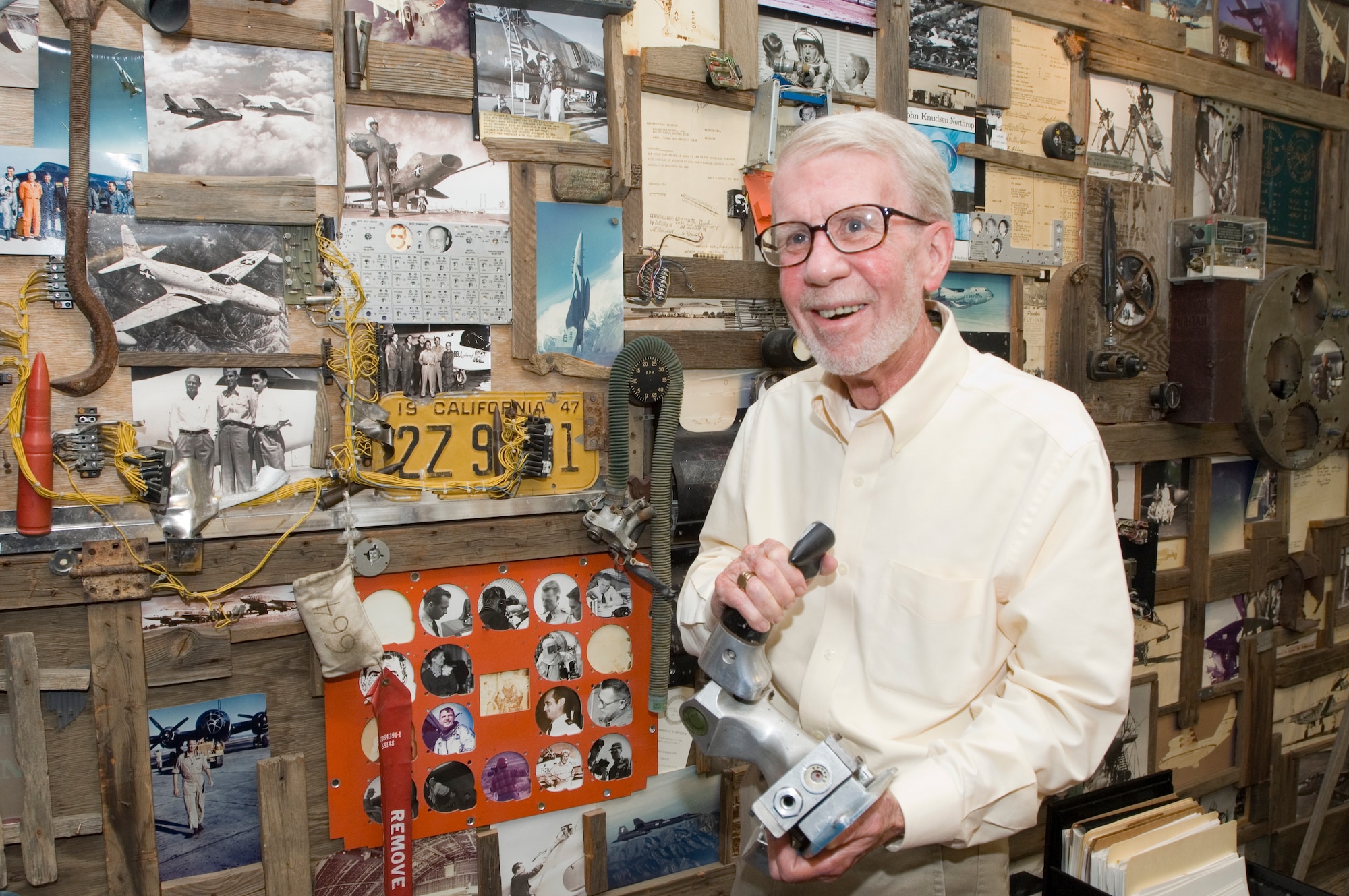 Dr. James Young stands in front of a wall of memorabilia in his office. Young retired after 30 years at Edwards – 26 of them as the Air Force Flight Test Center's Chief Historian. He officially retired July 28. (Air Force photo by Edward Cannon)