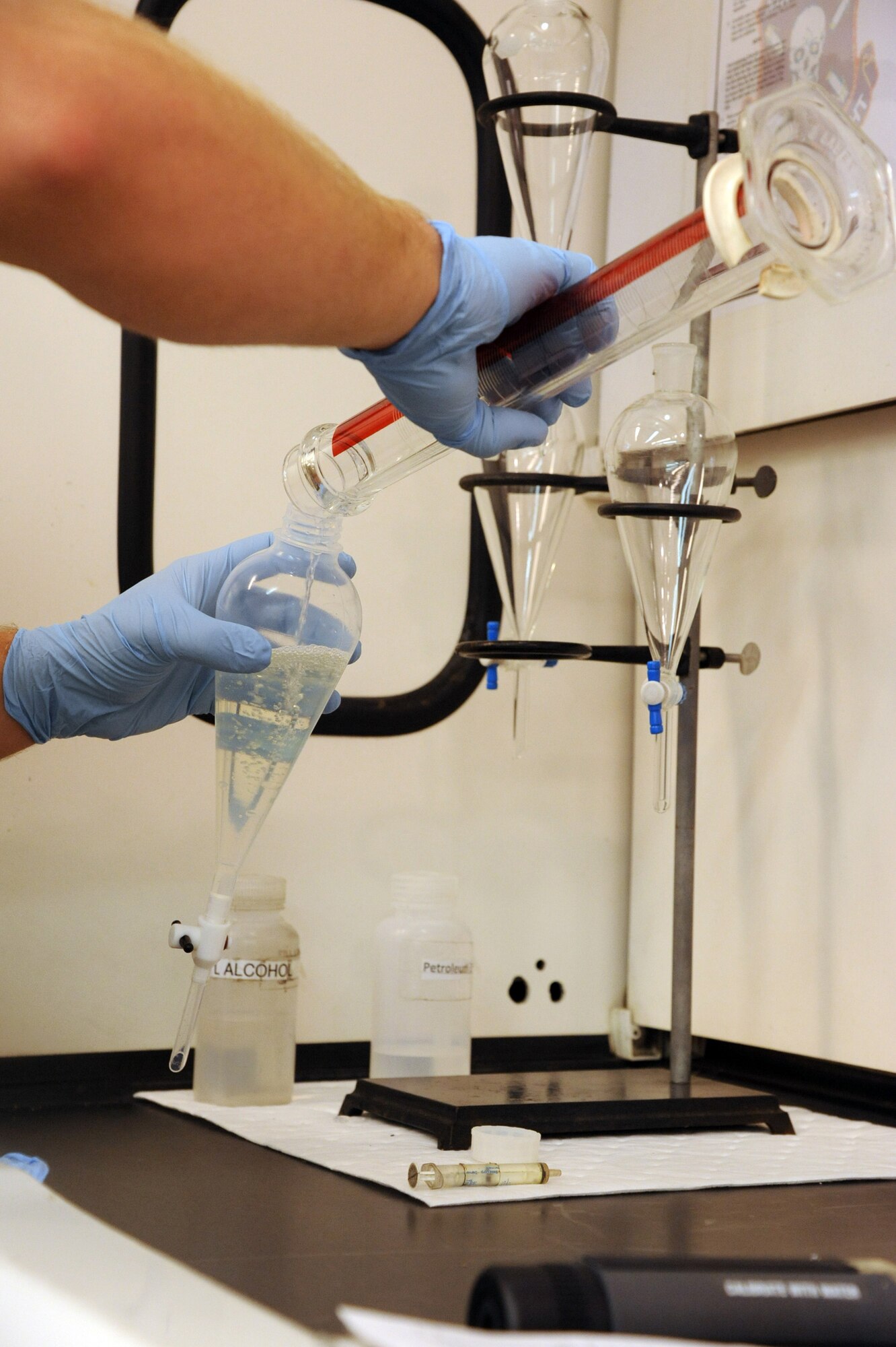 SEYMOUR JOHNSON AIR FORCE BASE, N.C.- Senior Airman William Thomas adds fuel to water during a fuel system icing inhibitor (FSII) test here Aug. 1, 2011. The FSII test determines the concentration of diethylene glycol monomethyl ether in jet fuel by refractive index. The test determines the concentration of FSII to ensure effective protection against the detrimental effect of free water. Thomas, 4th Logistics Readiness Squadron fuel lab technician, is a native of Parkersburg, W.Va. (U.S. Air Force photo by Senior Airman Whitney Lambert/ Released)