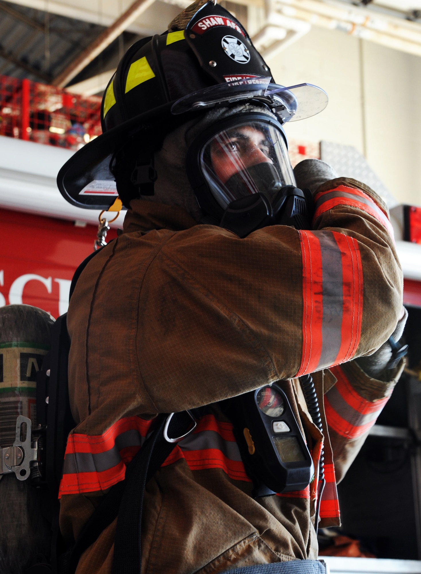 U.S. Air Force Airman 1st Class Aaron Hanson, 20th Civil Engineer firefighter, practices putting on the new M-7 Firehawk self-contained breathing apparatus at the fire station Shaw Air Force Base, S.C. Aug. 2, 2011. The new M-7 Firehawk helps Airmen complete the mission by being more durable, safer, user friendly and uses one tank instead of two. The mask has more features which include a voice enhancer and a heads up display that shows how much air is left in the tank. (U.S. Air Force photo/Airman 1st Class Tabatha L. Duarte)(Released)