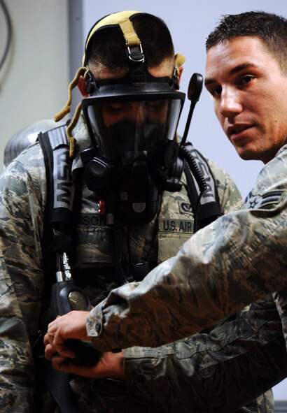 U.S. Air Force Airman 1st Class Danny Thompson, 20th Civil Engineer firefighter, demonstates to a class how to operate the new M-7 Firehawk self-contained breathing apparatus at the fire station Shaw Air Force Base, S.C. Aug. 2, 2011. The new M-7 Firehawk helps Airmen complete the mission by being more durable, safer, user friendly and uses one tank instead of two. The mask has more features which include a voice enhancer and a heads up display that shows how much air is left in the tank. (U.S. Air Force photo/Airman 1st Class Tabatha L. Duarte)(Released)