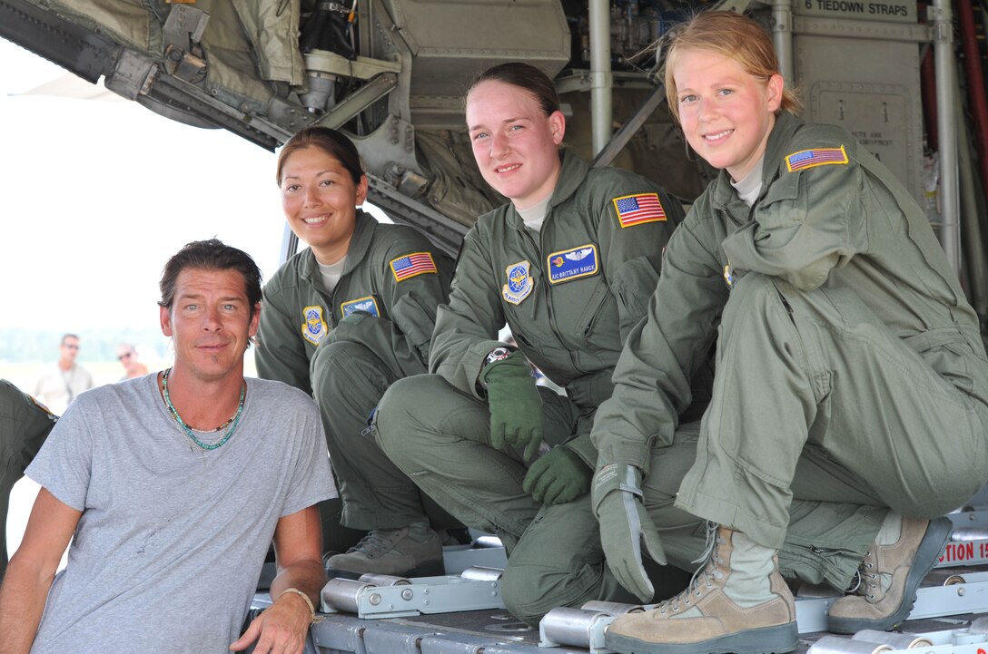 Assisting Extreme Makeover host Ty Pennington during filming  of aircraft loading operations at Pope Field, July 19, 2011 are loadmasters (left to right) Senior Airman Nicole Ramsey, 95th Airlift Squadron,  and Airman 1st Class Brittany Hauck, and Airman 1st Class Kasumi Bailey, both assigned to the 2nd Airlift Squadron. (U.S.Air Force photo by Senior Master Sgt. Kevin Brody)