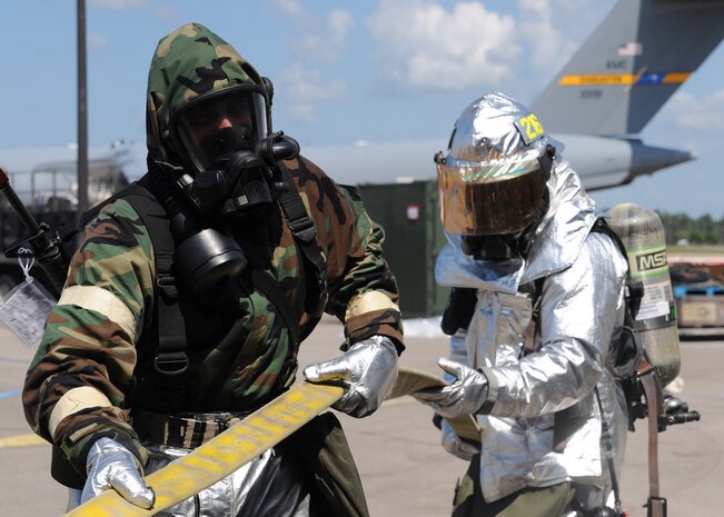 Firefighters from the 628th Civil Engineer Squadron feed hose to other firefighters who were inside of a simulated burning building during the Operational Readiness Exercise at Gulfport Training Center, Miss. July 31. (U.S. Air Force photo/Staff Sgt. Katie Gieratz)