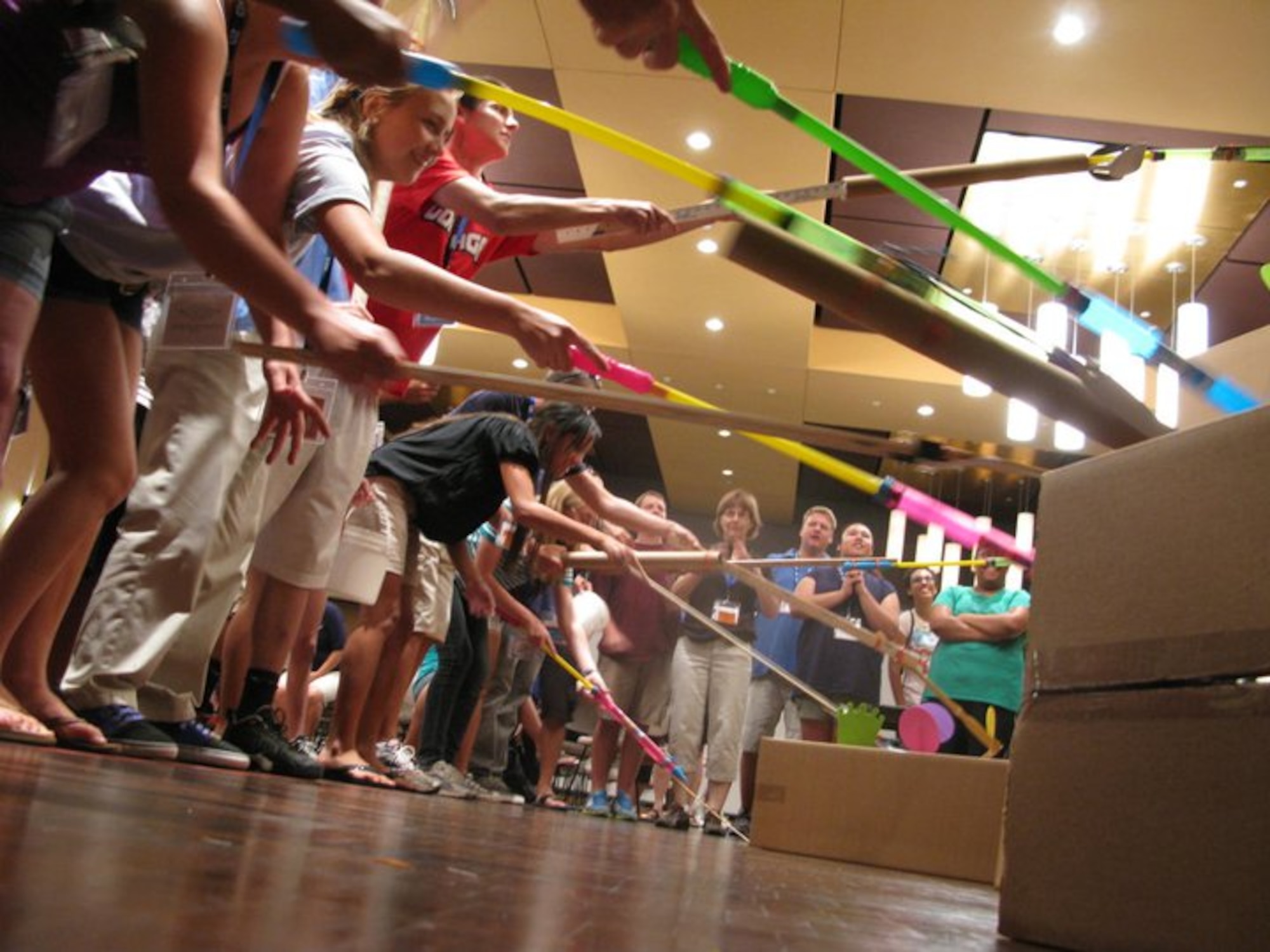 Teens use constructed poles to capture and retrieve lollipops and crowns from cardboxes during a challenge at the Air Force Teen Leadership Camp held July 11-15 at the University of Texas, San Antonio campus. to capture as many lollipops and crowns from the cardboard boxes. More than 80 teens from Air Force installations worldwide attended the camp to learn about college life, teamwork and leadership skills. (Courtesy photo)