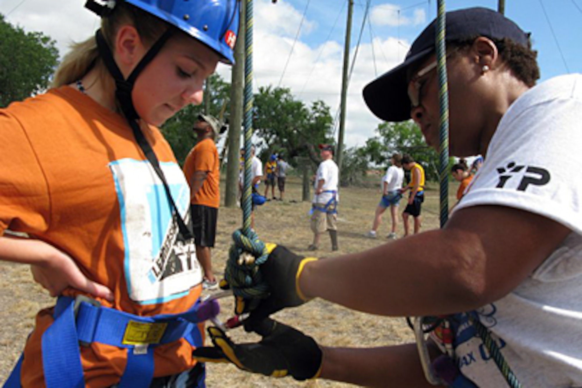 Morgan Erikson, an Air Force teen from Nellis Air Force Base, Nev., is strapped into her harness by Karen Hudson, a youth program specialist from Joint Base Charleston, S.C. during a high ropes challenge at Lackland Air Force Base, Texas July 12. The  challenge was part of an Air Force Teen Leadership Camp held in San Antonio July 11-15. More than 80 Air Force teens from Air Force installations worldwide learned about college life, teamwork and leadership skills during the camp. (Courtesy photo)