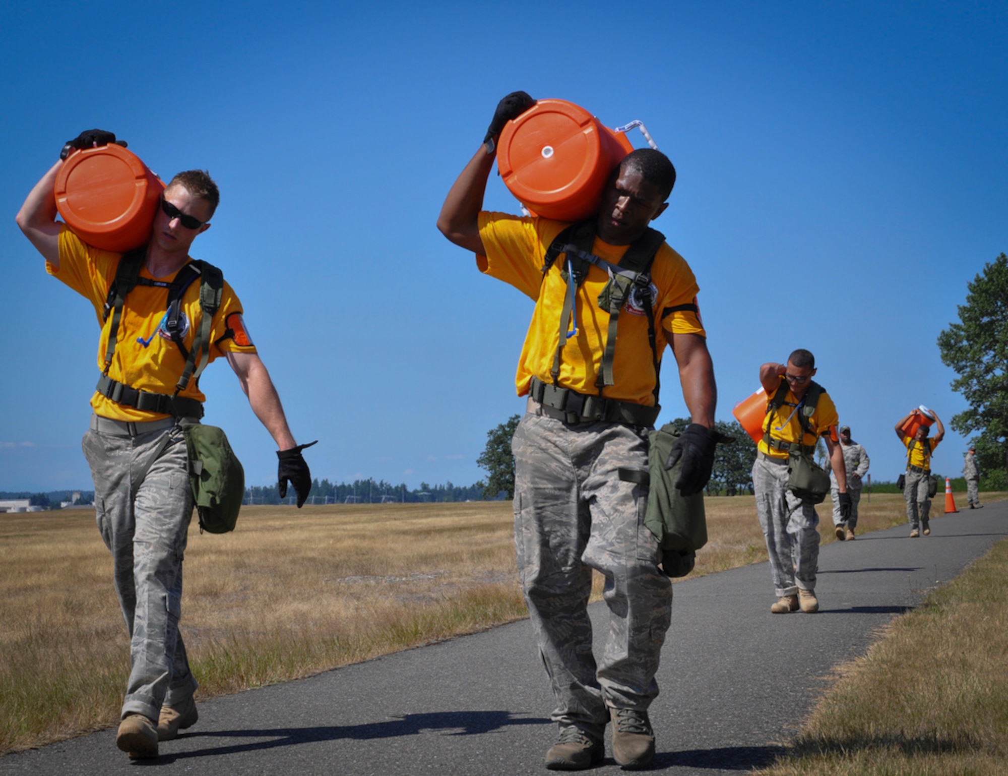 Tech. Sergeants Jeremy Starr and Oscar Merrit and Senior Airmen Eliezer Santiago and James Jackson carry coolers filled with water during the last leg of the Aerial Port Challenge Course. Throughout the course, the team ran 3.6 miles and completed 14 obstacles to challenge their physical ability and teamwork. (U.S. Air Force photo by 1st Lt. Carolyn Glover/Released)  