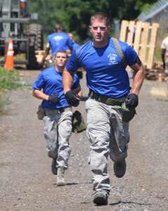 Staff Sgt. Nicholas Sansone (right) and Staff Sgt. Matthew Lumm, run during an aerial port obstacle course, July 28, 2011, at Joint Base Lewis-McChord, Wash. The course was part of Air Mobility Rodeo 2011, a biennial international competition that focuses on mission readiness, featuring airdrops, aerial refueling and other events that showcase the skills of mobility crews from around the world. Sansone and Lumm are air transportation specialist from the 437th Aerial Port Squadron. (U.S. Air Force photo /2nd Lt. Susan Carlson) 