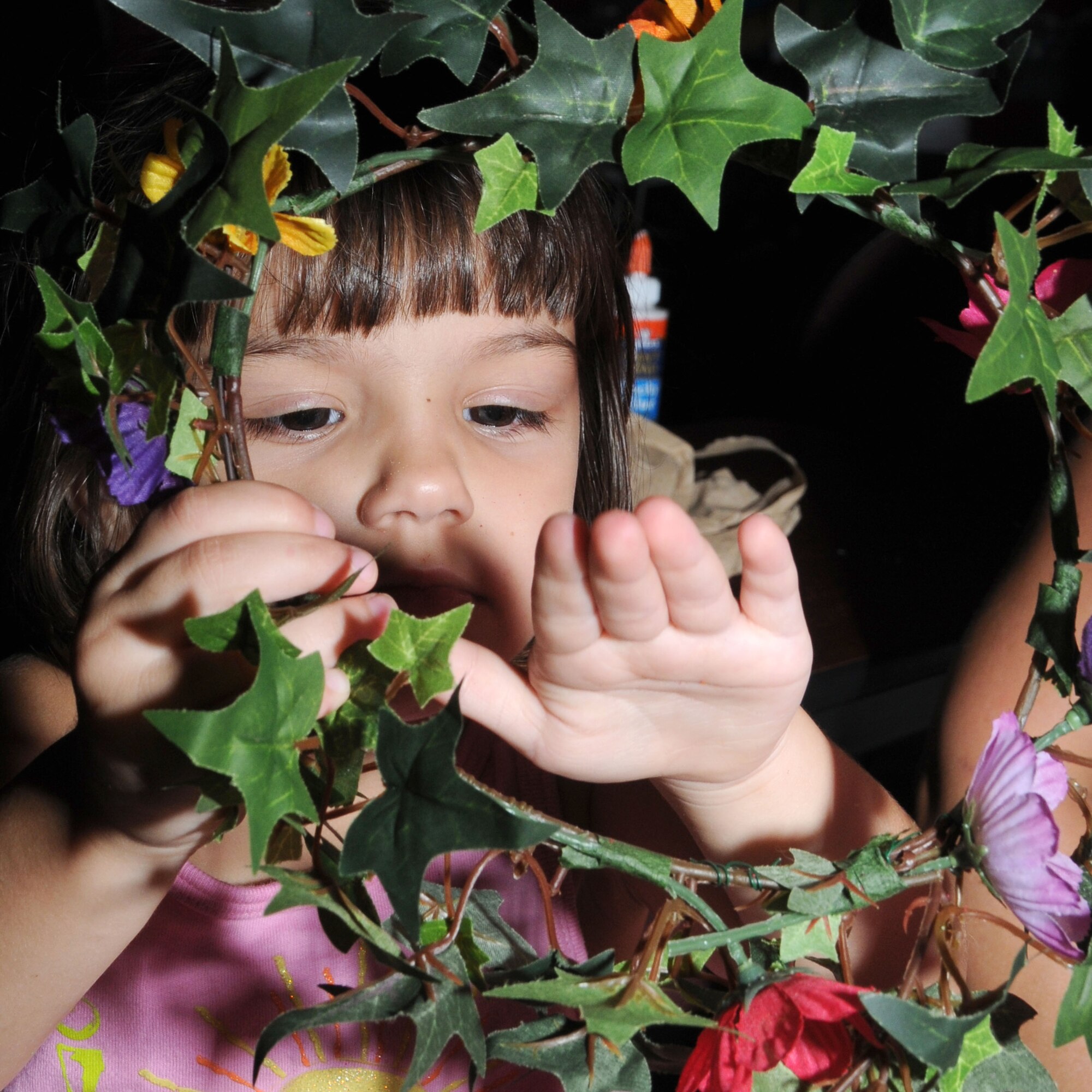 Marcella Kearns, 3, adjusts some of the leaves on the flower garland she made during the Medieval Faire at the Vandenberg Community Center July 28. Her parents are retiree Robert and Marcie Kearns of Gulfport. The event was the culmination of McBride Library’s A Midsummer Knight’s Read summer program. The children also made sand art in bottles and knight’s swords, played games and ate pizza.  (U.S. Air Force photo by Kemberly Groue)