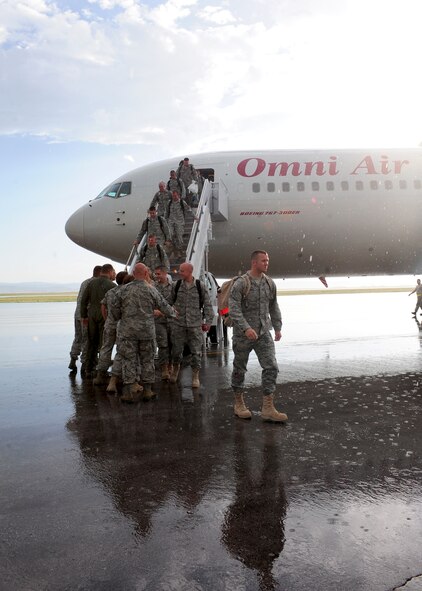 37th Bomb Squadron Airmen step off an airliner after returning from a six month deployment to Southwest Asia, at Ellsworth Air Force Base, S.D., July 27, 2011. The men and women of the 37th BS were met by a crowd of loved ones eagerly awaiting their arrival. (U.S. Air Force photo/Airman Alystria Maurer/Released)