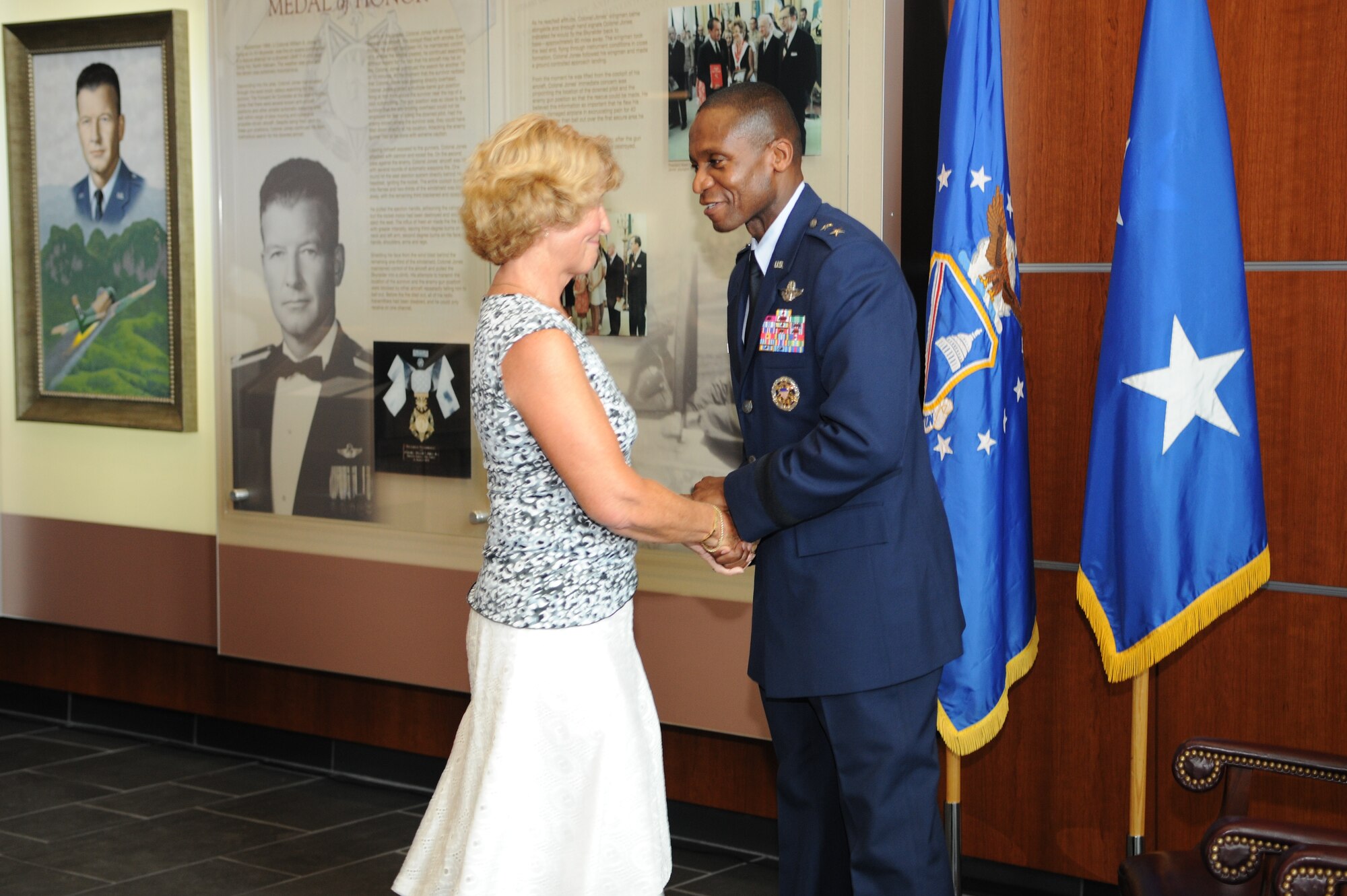 Anne Gilfillan, first daughter of Col. William A. Jones III, thanks Maj. Gen. Darren McDew, Air Force District of Washington commander, after he spoke at a display dedication in the new William A. Jones III Building on July 28. The display honors the life and service of Medal of Honor recipient Col. William A. Jones III, a former air commando with the 602nd Special Operations Squadron and A-1 Sky Raider pilot during the Vietnam War. (U.S. Air Force photo/Staff Sgt. Kris Levasseur)
