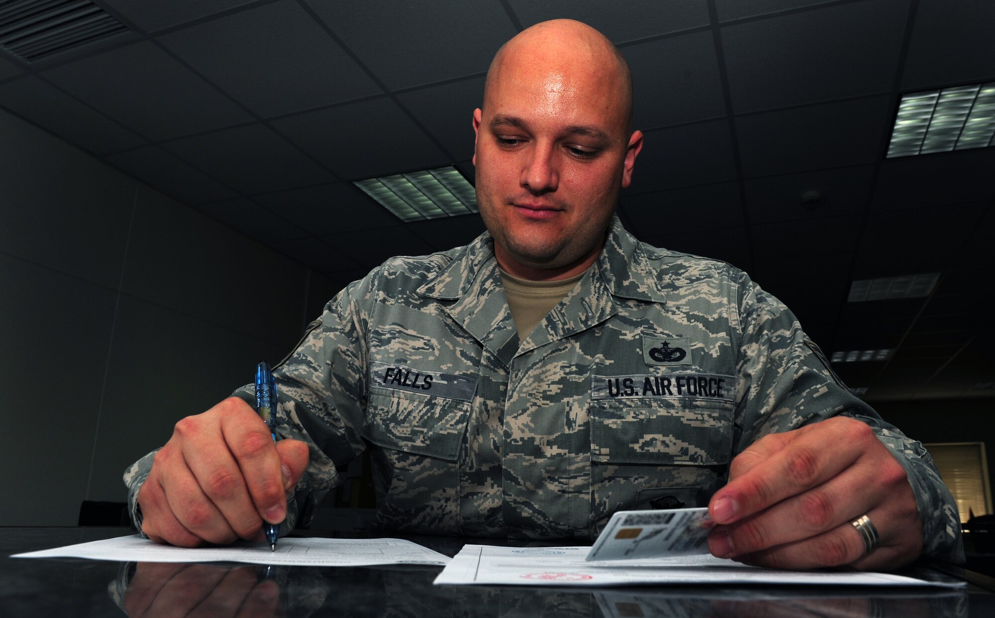 Tech. Sgt. Brian Falls, 39th Security Forces Squadron pass and identification NCO in charge, fills out paperwork for a gate pass Aug. 2, 2011, at Incirlik Air Base, Turkey. Falls recently graduated from Kisling NCO Acadamy at Ramstein Air Base, Germany July 14, 2011, as a distinguished graduate. (U.S. Air Force photo by Senior Airman Anthony Sanchelli/Released)
