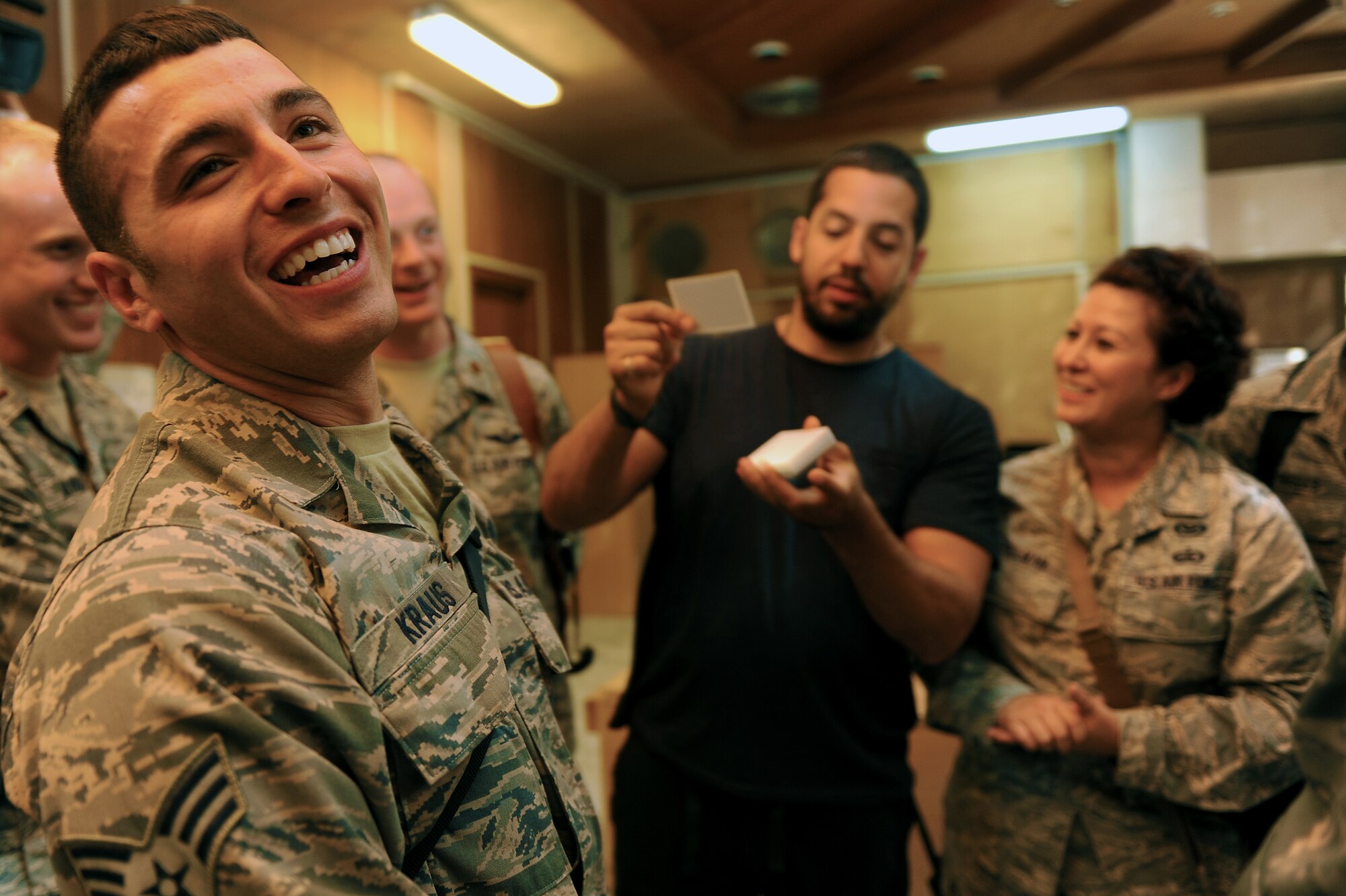 Senior Airman Corey Kraus, 447th Expeditionary Civil Engineer Squadron, is amazed by a card trick performed by David Blaine, a world famous illusionist, during a visit to Sather Air Base, Iraq, Aug. 2, 2011. Karl Malone, former National Basketball Association professional basketball player, and Blaine visited Airmen here as part of a three country, six-day United Service Organizations, or USO tour. Kraus, from Dayton, Ohio, is deployed from the 509th Civil Engineer Squadron, Whiteman Air Force Base, Missouri. (U.S. Air Force photo/Staff Sgt. Mike Meares)