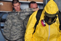 KUNSAN AIR BASE, Republic of Korea -- Airmen from the 8th Maintenance Squadron crash and recovery, help Col. Scott Pleus, 8th Fighter Wing commander, put on a chemical suit here, August 2. Col. Pleus visited each section of the Maintenance Group as part as his Immersion tour of the base. (U.S. Air Force photo/Senior Airman Brittany Y. Bateman)