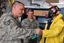 KUNSAN AIR BASE, Republic of Korea -- Airmen from the 8th Maintenance Squadron crash and recovery, help Col. Scott Pleus, 8th Fighter Wing commander, put on a chemical suit here, August 2. Col. Pleus visited each section of the Maintenance Group as part as his Immersion tour of the base. (U.S. Air Force photo/Senior Airman Brittany Y. Bateman)