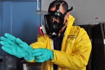 KUNSAN AIR BASE, Republic of Korea -- Airmen from the 8th Maintenance Squadron crash and recovery, help Col. Scott Pleus, 8th Fighter Wing commander, put on a chemical suit here, August 2. Col. Pleus visited each section of the Maintenance Group as part as his Immersion tour of the base. (U.S. Air Force photo/Senior Airman Brittany Y. Bateman)