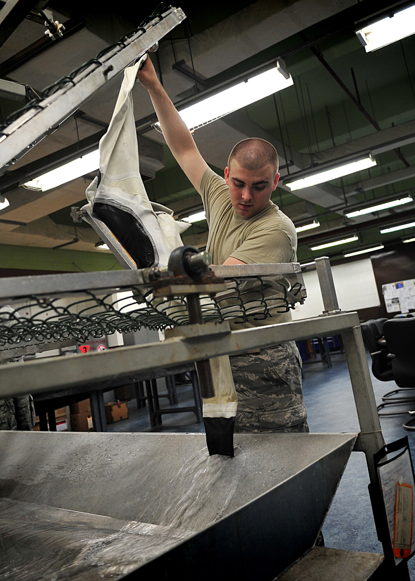 An Air Crew Flight Equipment Journeyman, Senior Airman Anthony Sportsman from the 51st Operation Support Squadron inspected an anti-exposure suit using the water tester.  Airman Sportsman sealed the feet, arms and neck openings of the anti exposure suit.  Once sealed, he filled the suit with water.  After the suit was completely filled with water, he looked for beads of water to form [an indication of a small hole or tear].  In the event that a small hole or tear is found Airman Sportsman circles the area with a black grease pencil.  When all the holes are found and circled, Airman Sportsman then empties the suit, turns it inside-out and sets it to dry for the necessary repairs to be made.  The anti-exposure suit is a vital operational item and mandatory for pilots that fly over waters that have a temperature of 50 degrees or below.(U.S. Air Force Photo by/Staff Sgt. Daylena Gonzalez)