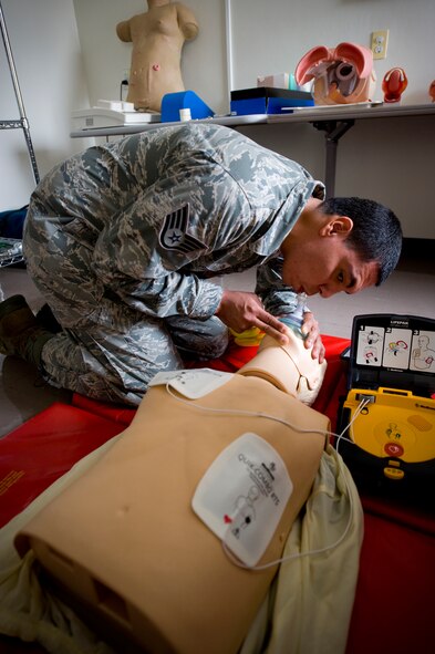 YOKOTA AIR BASE, Japan --  Staff Sgt. Louis Favela, 374th Medical Operations Squadron aerospace medical technician uses the head-tilt, chin-lift, mouth-to-mouth resuscitation technique to open a simulated victim's airway. Sergeant Louis demonstrates how to properly administer CPR in combination with an automated external defibrillator at Yokota Air Base, Japan, Aug. 2, 2011. The AED's electrical contacts are placed on the bare chest of an unconscious victim. From there, the AED gives verbal instructions on what to do next and can potentially play a vital role in saving a life. (U.S. Air Force photo/Staff Sgt Stacy Moless)