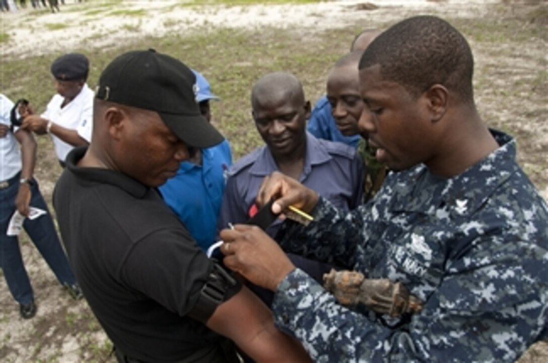 U.S. Navy Petty Officer 2nd Class Eseosa Osemwota (right) instructs a group of Nigerian service members on the proper application of a tourniquet during a tactical combat casualty care course as part of Africa Partnership Station West in Lagos, Nigeria, on Aug. 2, 2011.  Africa Partnership Station is an international security cooperation initiative facilitated by Commander, U.S. Naval Forces Europe-Africa aimed at strengthening global maritime partnerships through training and collaborative activities in order to improve maritime safety and security in Africa.  