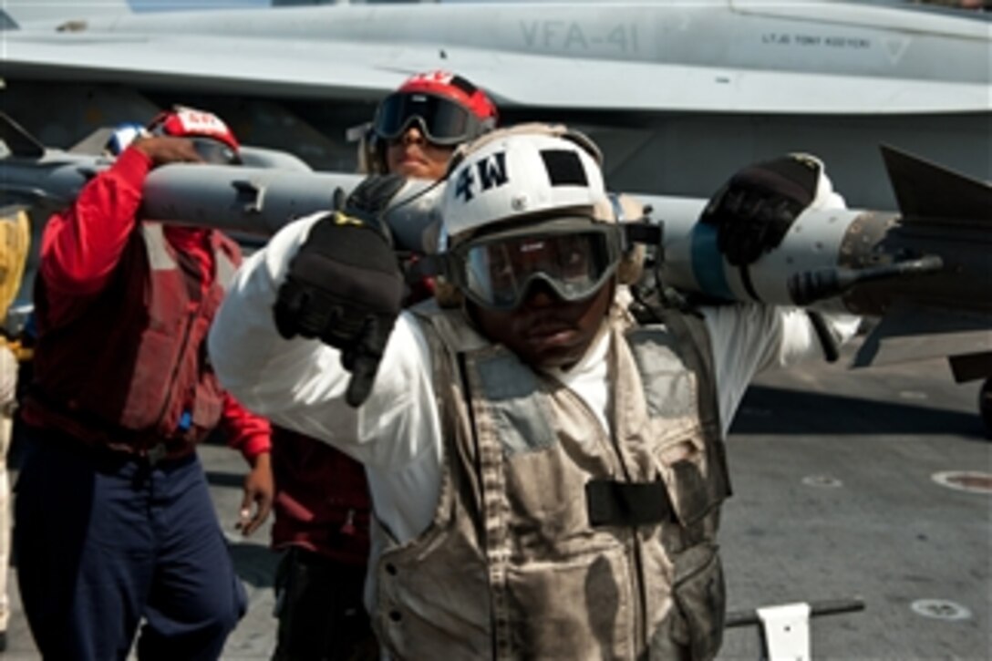 U.S. Navy aviation ordnancemen transfer ordnance on the flight deck of the aircraft carrier USS John C. Stennis (CVN 74) during preparations for deployment at Naval Air Station North Island in Coronado, Calif., on July 29, 2011.  The John C. Stennis Carrier Strike Group was deployed in support of maritime security operations and theater security cooperation efforts in the U.S. 5th Fleet area of responsibility.  