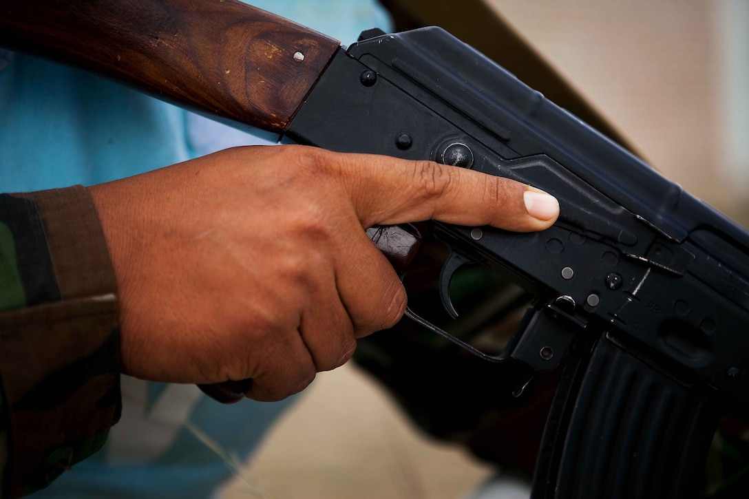 A soldier from the Cambodian National Peacekeeping Platoon, Cambodian army, switches his weapon to safe after firing blank rounds into the air to disburse rioting role-players during distribution site security training during the field training exercise at Exercise Khaan Quest 2011 at Five Hills Training Area near Ulaanbaatar, Mongolia, Aug. 1. The platoon trained to protect food, water and humanitarian supplies at a distribution site within the scenario. The multinational training was conducted with the combined expertise of all participating nations, including Indonesia, Mongolia, Republic of Korea and India. Khaan Quest is a training exercise designed to strengthen the capabilities of participating nations’ forces in international peace support operations worldwide.