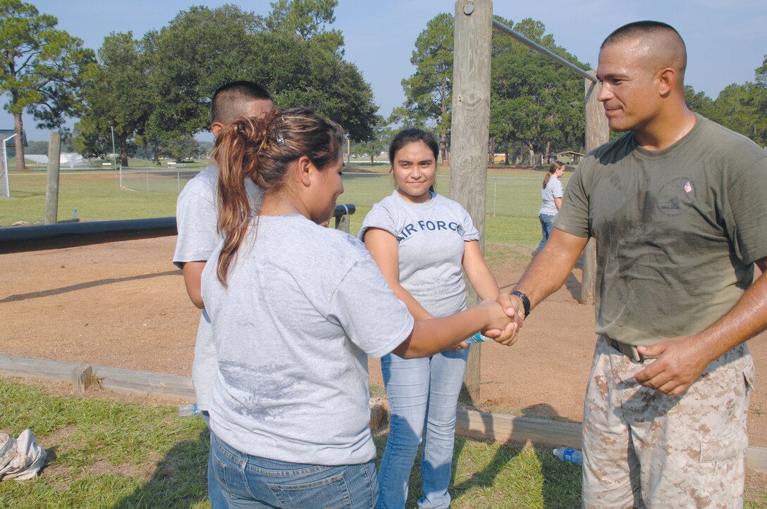 Master Sgt. Mark Carabello congratulates a cadet on completing the at the Marine Corps Logistics Base Albany obstacle course, Aug. 4. The nearly 70 teenagers, in grades 9-12, were JROTC members from Tift County High School, who were participating in the final leg of their two-week summer leadership training at the base.