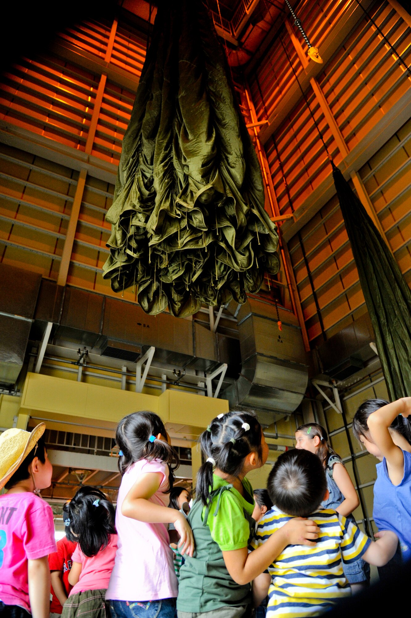 YOKOTA AIR BASE, Japan -- Students from Caesar's Creek School in Hanno, Japan, observe the opening of a G-12 E parachute at Yokota Air Base, Japan, August 2, 2011. The students received a tour through the combat mobility flight shop.  (U.S. Air Force photo/Airman 1st Class Krystal M. Garrett) 