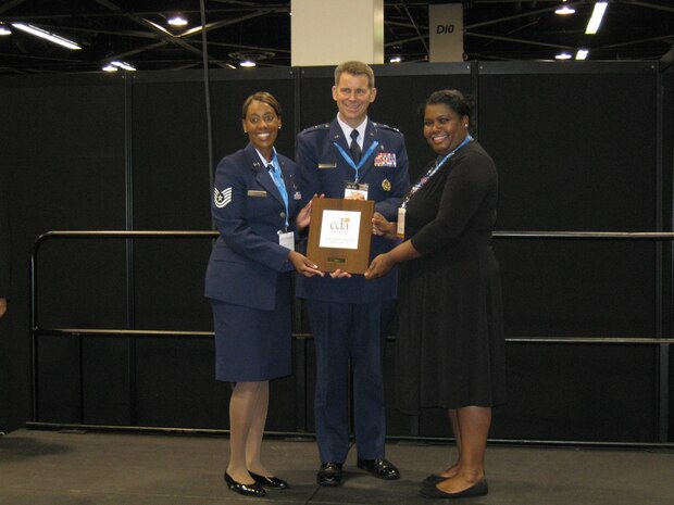 Maj. Gen. Gerard Caron, Air Force Dental Services assistant surgeon general and 79th Medical Wing commander, presents an honorary mention award to Tech. Sgt. Tiffany Hutchins, 99th Dental Squadron advanced education of general dentistry residency flight NCO in charge, Lydia Champion, 99 DS dental technician, and Staff Sgt. Taurean Gardner (not present),  99 DS advanced education of general dentistry flight NCO, during the awards ceremony for the California Dental Association table clinic competition held May 14, 2011, in Anaheim, Calif.  The competition recognized Hutchins and Champion for their table clinic entitled “Management and Prevention of Dental Caries in Children,” out of the 48 table clinic presenters who were from the Air Force, Navy and Veteran’s Affairs. (Courtesy photo)