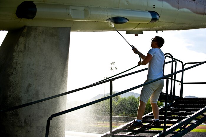 U.S. Air Force Senior Airman James Nash, 757th Aircraft Maintenance Squadron avionics journeyman, power washes the side of a F-105 Thunderchief static display July 29, 2011, at Nellis Air Force Base, Nev. Senior Airman Nash is among a group of volunteers from the 57th and 757th Aircraft Maintenance Squadrons that washed the airplane static displays for the first time in a new plan to wash them once every quarter. (U.S. Air Force photo by Airman 1st Class George Goslin/Released)