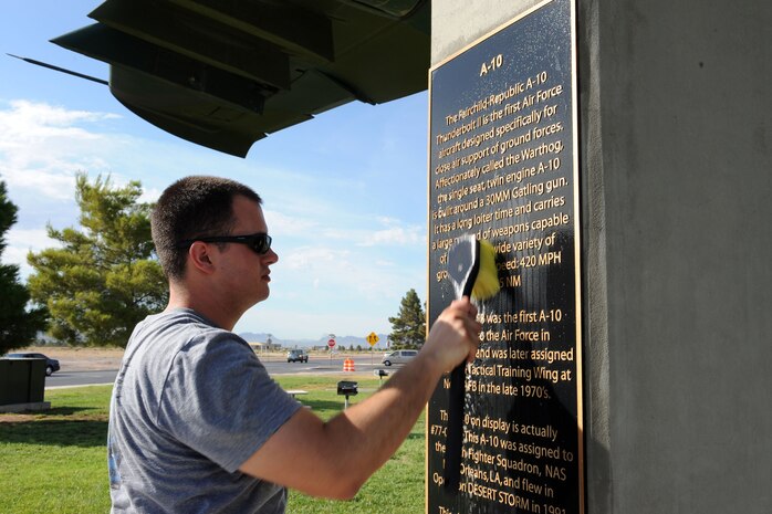 U.S. Air Force Airman 1st Class Joshua Necessary, 57th Aircraft Maintenance Squadron crew chief, washes the plaque of the A-10 Thunderbolt II static display July 29, 2011, at Nellis Air Force Base, Nev. Airman 1st Class Necessary is among a group of volunteers from the 57th and 757th Aircraft Maintenance Squadrons tasked with cleaning and inspecting the static display aircraft at Freedom park for the first time, the goal is to create a regular cleaning schedule for the aircraft to help prevent corrosion and pro-long their lifespan. (U.S. Air Force photo by Staff Sgt. Taylor Worley/Released)