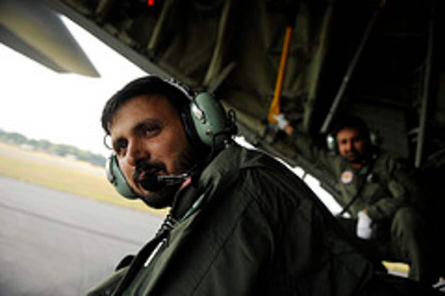 Pakistan air force Chief Warrant Officer Abdul Majid, Number 6 Air Transport Squadron, ensures the area is clear while backing up in a C-130E Hercules before a training mission to prepare for Rodeo 2011 at Joint Base Lewis-McChord, Wash., July 22, 2011.  Air Mobility Rodeo is the U.S. Air Force's and Air Mobility Command’s premier international combat skill and flying operations competition designed to develop and improve techniques, procedures and interoperability, while optimizing international mobility partnerships and enhancing mobility operations. (U.S. Air Force Photo Staff Sgt. Eric Harris)
