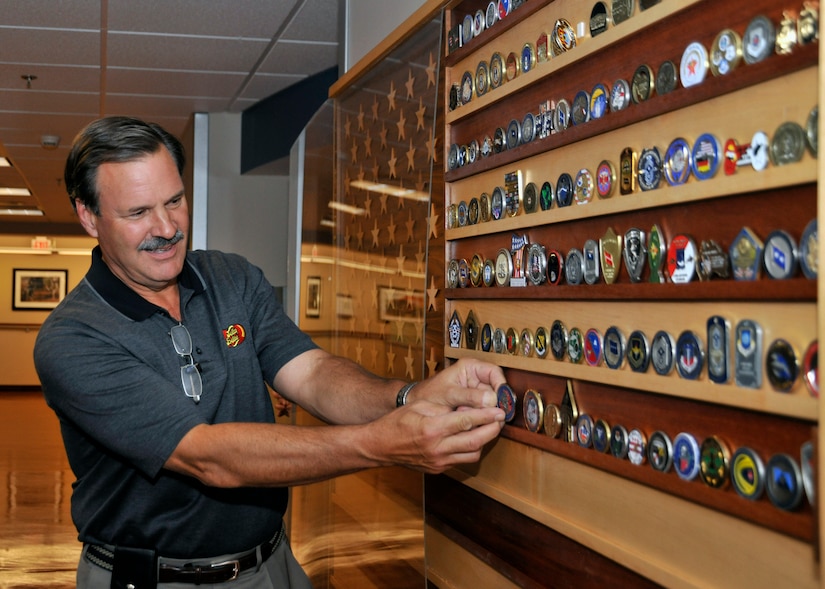 Robert M. Simpson, Jr. Jelly Belly Candy Company President and Chief Operating Officer, adds a coin to the collection at the 779th Aeromedical Staging Facility after receiving a tour here July 13. Simpson and Herman G. Rowland Sr., Jelly Belly Candy Company Chairman of the Board, participated in the Andrews Leadership Series, an initiative spearheaded by Col. Kenneth Rizer, 11th Wing/Joint Base Andrews commander. The series showcases high profile military and civic members who are leaders in their respective field. The program also aims to educate servicemembers about the characteristics of being a leader and provides JBA members with the tools they need to become better leaders themselves. (U.S. Air Force photo/Senior Airman Laura Turner)