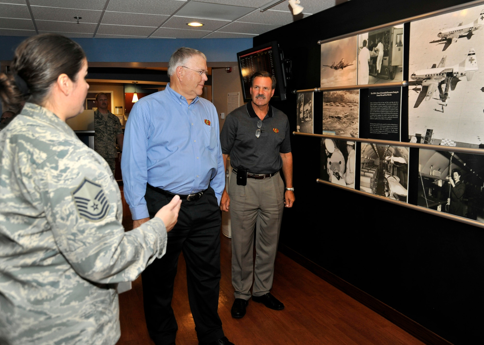 Master Sgt. Michelle Tancrede, NCO in charge of mission operations, 779th Aerospace Medicine Squadron, shows Robert M. Simpson Jr., Jelly Belly Candy Company President and Chief Operating Officer, and Herman G. Rowland Sr., Jelly Belly Candy Company Chairman of the Board, the Heritage Wall during their tour of the 779th Aeromedical Staging Facility here July 13. Simpson and Rowland participated in the Andrews Leadership Series, an initiative spearheaded by Col. Kenneth Rizer, 11th Wing/Joint Base Andrews commander. The series showcases high-profile military and civic members who are leaders in their respective field. The program also aims to educate servicemembers about the characteristics of being a leader and provides JBA members with the tools they need to become better leaders themselves. (U.S. Air Force photo/Senior Airman Laura Turner)