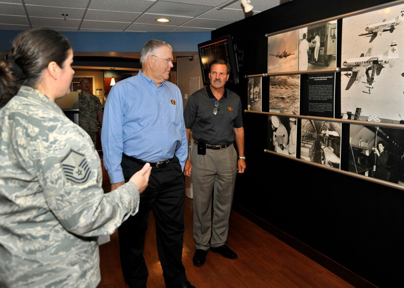 Master Sgt. Michelle Tancrede, NCO in charge of mission operations, 779th Aerospace Medicine Squadron, shows Robert M. Simpson Jr., Jelly Belly Candy Company President and Chief Operating Officer, and Herman G. Rowland Sr., Jelly Belly Candy Company Chairman of the Board, the Heritage Wall during their tour of the 779th Aeromedical Staging Facility here July 13. Simpson and Rowland participated in the Andrews Leadership Series, an initiative spearheaded by Col. Kenneth Rizer, 11th Wing/Joint Base Andrews commander. The series showcases high-profile military and civic members who are leaders in their respective field. The program also aims to educate servicemembers about the characteristics of being a leader and provides JBA members with the tools they need to become better leaders themselves. (U.S. Air Force photo/Senior Airman Laura Turner)
