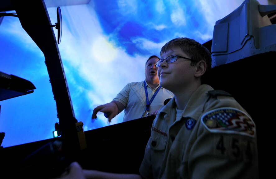 Trey D’Amico, Troop 454 Boy Scout, operates A-10 simulator controls with assistance from Steven Callich, 23rd Operations Support Squadron A-10 simulator instructor pilot, at Moody Air Force Base, Ga., July 31, 2011. Trey went through steps to earn an aviation merit badge, which included classroom sessions about aircraft and their capabilities. (U.S. Air Force photo by Airman 1st Class Joshua Green/Released)
