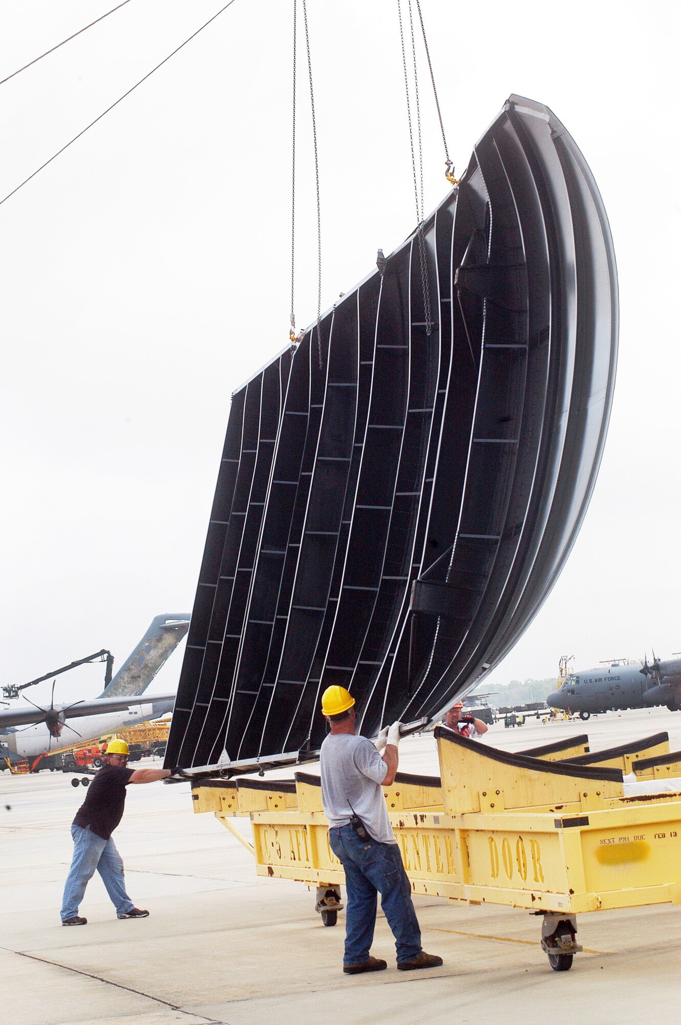 C-5 maintainers guide a C-5  cargo door onto a cradle July 27. U. S. Air Force photo by Sue Sapp