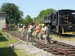 Soldiers from the 1152nd Rail Company, 757th Railway Operating Battalion, align sections of track and add ballast during the construction of a rail spur at the Army Transportation Museum. It took nearly two dozen reservists from the Midwest almost three weeks to lay the 572 feet of railway to move new additions to the museum into place. (Photo courtesy Army Transportation Museum)